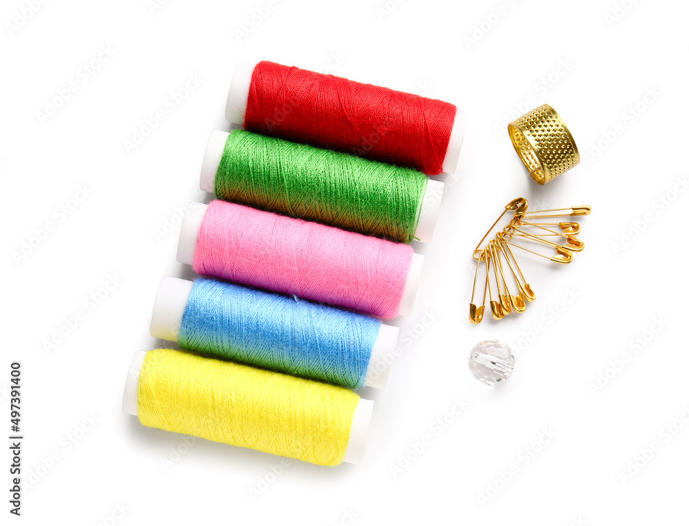 Thread spools with pins on white background Thread spools with pins on white background