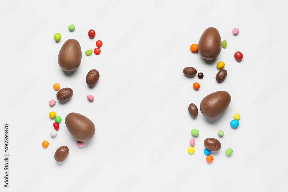 Delicious chocolate eggs and candies on light background Delicious chocolate eggs and candies on light background