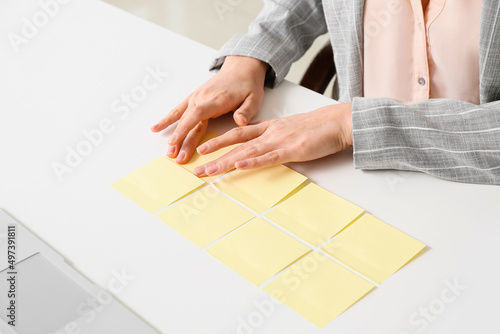 Young manager with sticky note papers at her workplace, closeup © Pixel-Shot