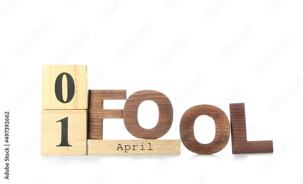 Wooden cube calendar with date 1 APRIL and word FOOL on white background Wooden cube calendar with date 1 APRIL and word FOOL on white background