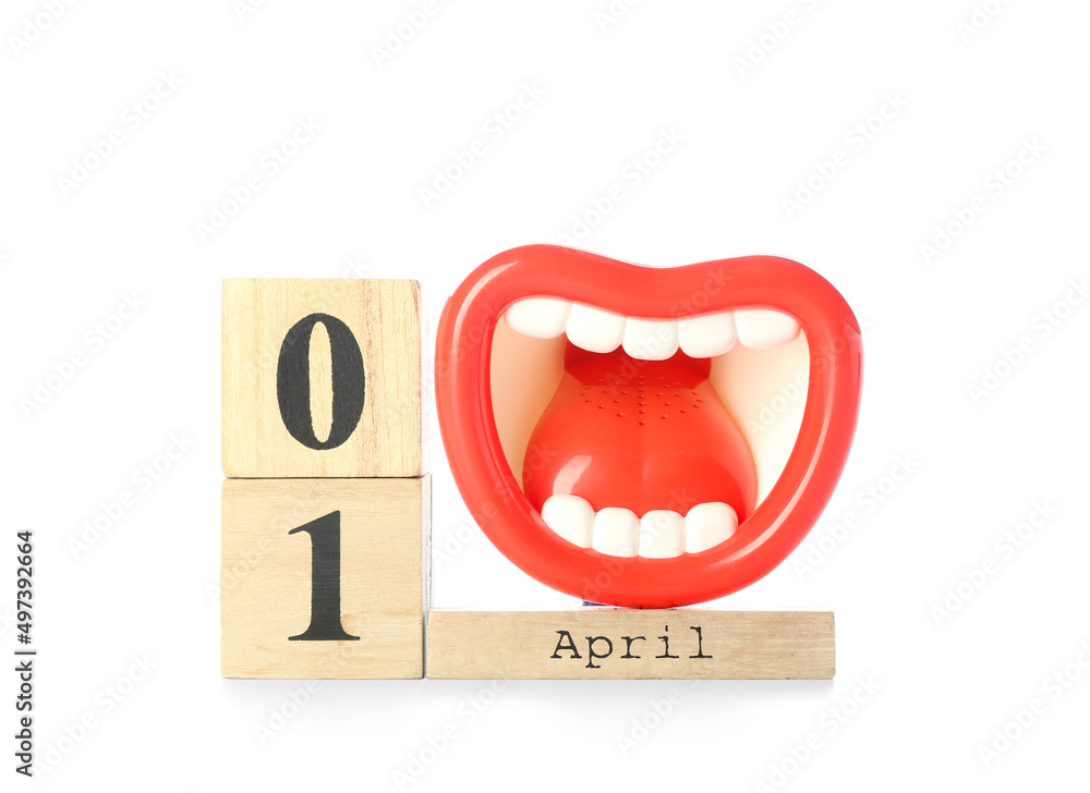 Wooden cube calendar and megaphone on white background. April Fools Day celebration Wooden cube calendar and megaphone on white background. April Fools Day celebration