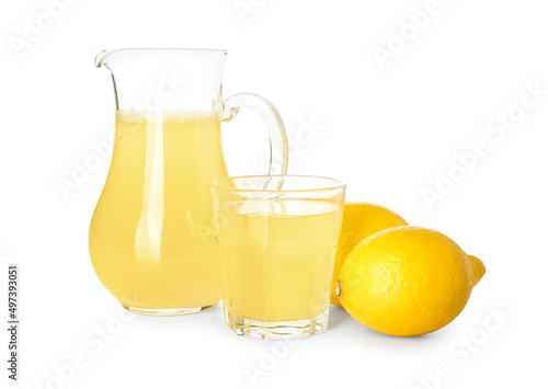 Jug and glass with fresh lemon juice on white background