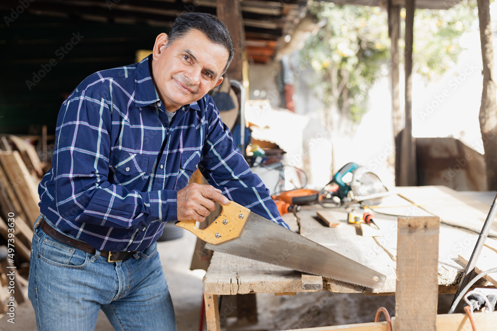 Hispanic man working with saw in his carpentry workshop-Latin Carpenter working Hispanic man working with saw in his carpentry workshop-Latin Carpenter working