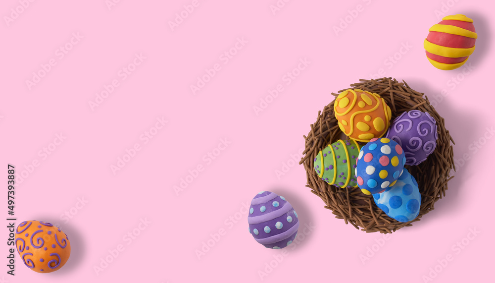 Nest with eggs made of plasticine on a pink background and copy space. Top view. Easter minimal concept. Flat lay