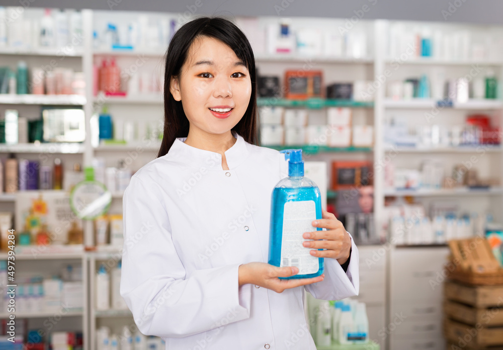 Diligent friendly chinese female pharmacist offers an antibacterial agent in modern pharmacy