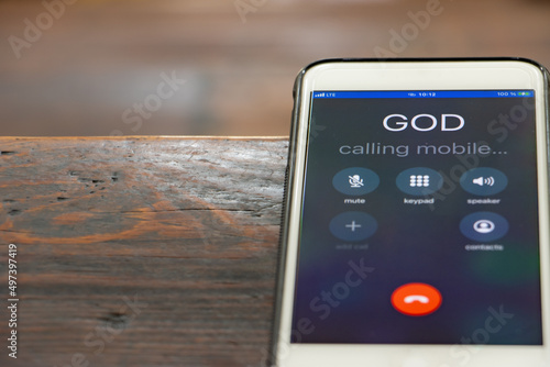 Calling God with a mobile phone on the table of a prayer bench in the church, close up. photo