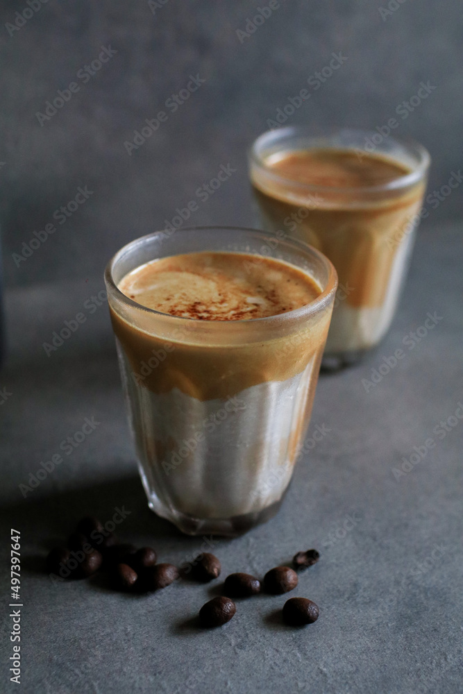 Dirty latte coffee mixed with cold fresh milk in the morning on dark background. Coffee shop cafe. Dirty latte coffee mixed with cold fresh milk in the morning on dark background. Coffee shop cafe.