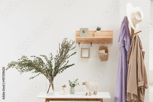 Wooden clothes rack and key holder on white wall in hallway