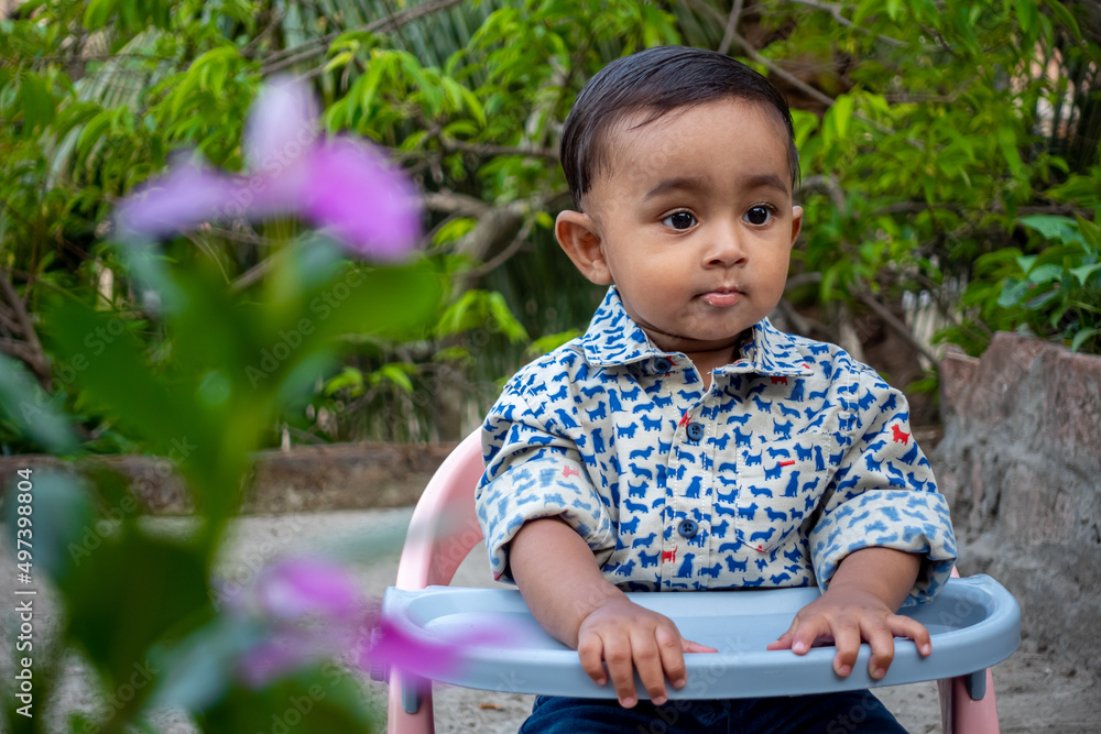 T-shirt and jeans pants Wearing an infant sitting in a chair in the green garden. Baby's beautiful face on a beautiful afternoon. Asian cute baby boys portrait on rooftop. T-shirt and jeans pants Wearing an infant sitting in a chair in the green garden. Baby's beautiful face on a beautiful afternoon. Asian cute baby boys portrait on rooftop.