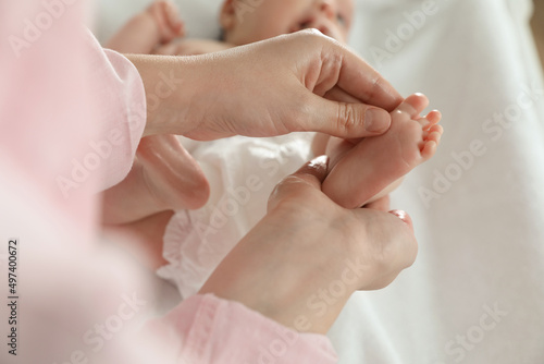 Mother massaging her cute baby with oil, closeup