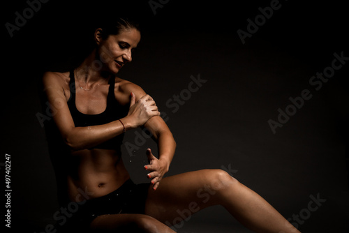 Sexy fit girl in sportswear on the ground. Magnesium powder prints of hands on her body..