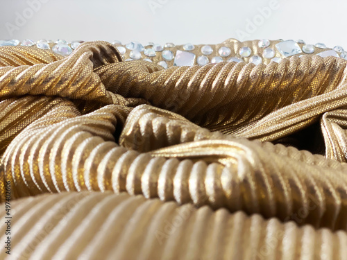 Golden texture dress or cloth with white transparent gems for background ornament