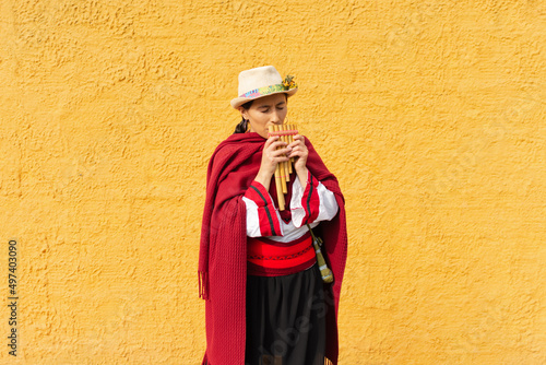 Obraz na płótnie Portrait of an indigenous woman with a hat and typical costume playing an Andean