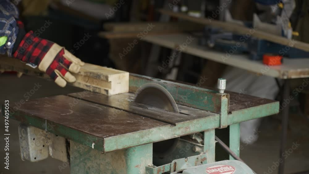 A piece of wood is cut using a circular table saw. A piece of wood is cut using a circular table saw.