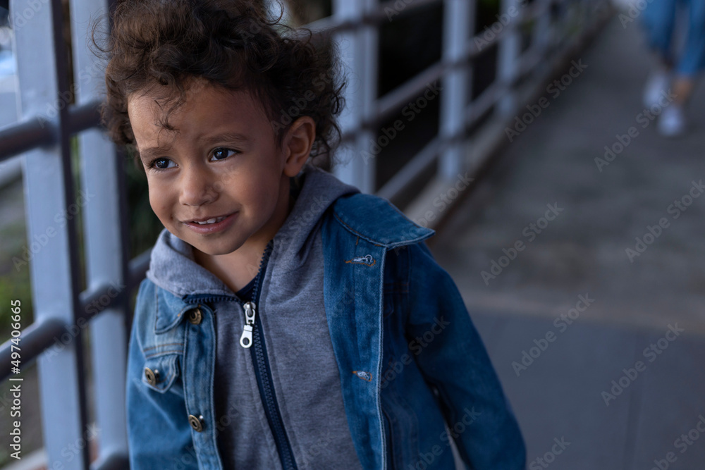 Latin American boy walking alone in front of his mother. Concept going for a walk, motherhood Latin American boy walking alone in front of his mother. Concept going for a walk, motherhood