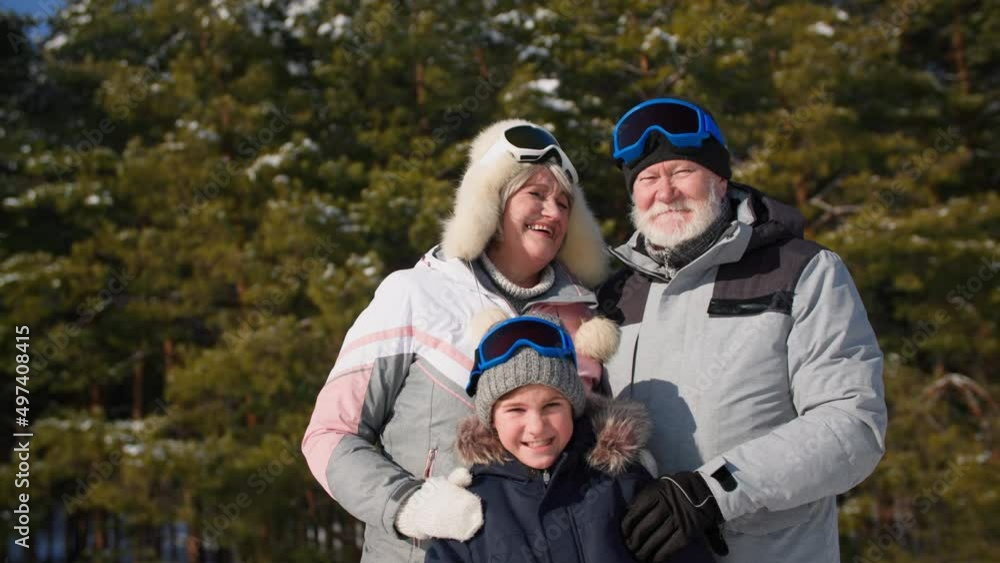 portrait of a happy elderly man and woman in a match with my boy stand background of trees while walking in forest in winter in sunny weather portrait of a happy elderly man and woman in a match with my boy stand background of trees while walking in forest in winter in sunny weather