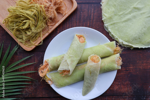 Roti Saimai - Thai dessert of cotton candy burrito pancake or crepe at top view of wood table photo