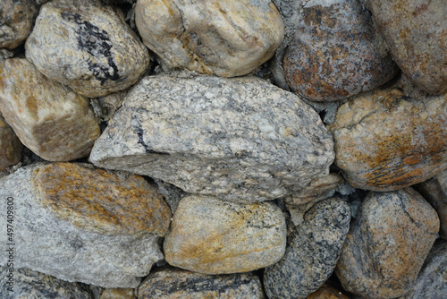 cobble of gneiss metamorphic stones on the rock wall.
