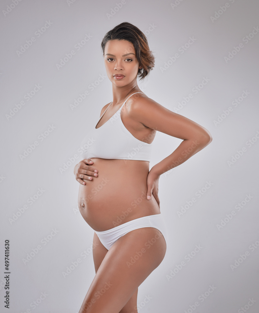 Obraz premium Beautiful is a mother to be. Studio portrait of a beautiful young pregnant woman posing against a gray background.