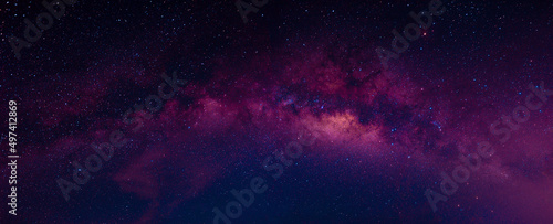 Milky way in the night sky and stars on dark background with noise and grain. Photo taken with long exposure and white balance selected.