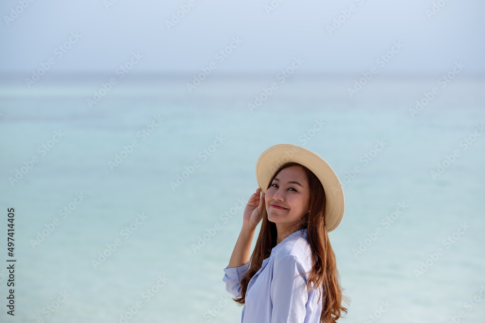 Portrait image of a beautiful young asian woman while strolling on the beach by the sea Portrait image of a beautiful young asian woman while strolling on the beach by the sea