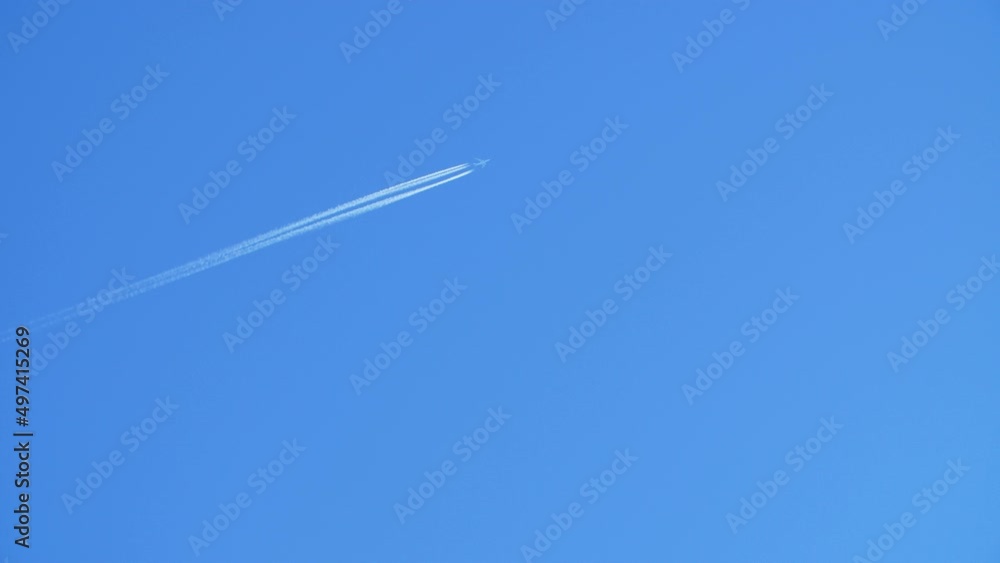 Jet airliner flying high in the sky leaves contrails in the clear blue sky. Jet airliner flying high in the sky leaves contrails in the clear blue sky.