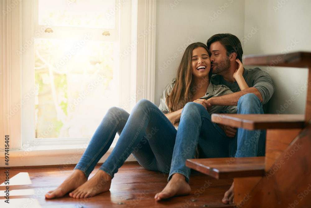 We are both the same in every way. Shot of an affectionate young couple sitting in a corner and holding each other. We are both the same in every way. Shot of an affectionate young couple sitting in a corner and holding each other.