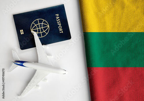Flag of Lithuania with passport and toy airplane. Flight travel concept