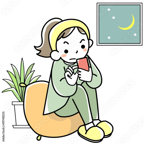 スマホを見ながら夜更かしする若い女性