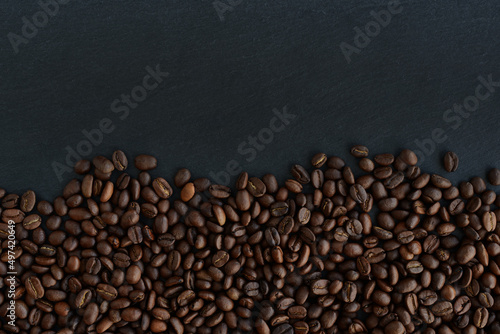 Roasted Coffee beans on a black background. Top view. Copy space © maxa0109
