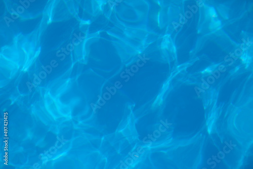 Beautiful blue water background. Texture of water surface of pool is transparent, clean water with light refraction and reflection on water surface, with copy place. 