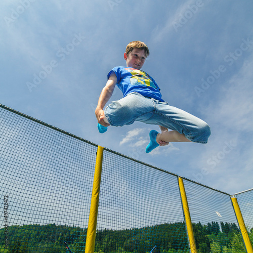Junge springt ausgelassen auf dem Trampolin