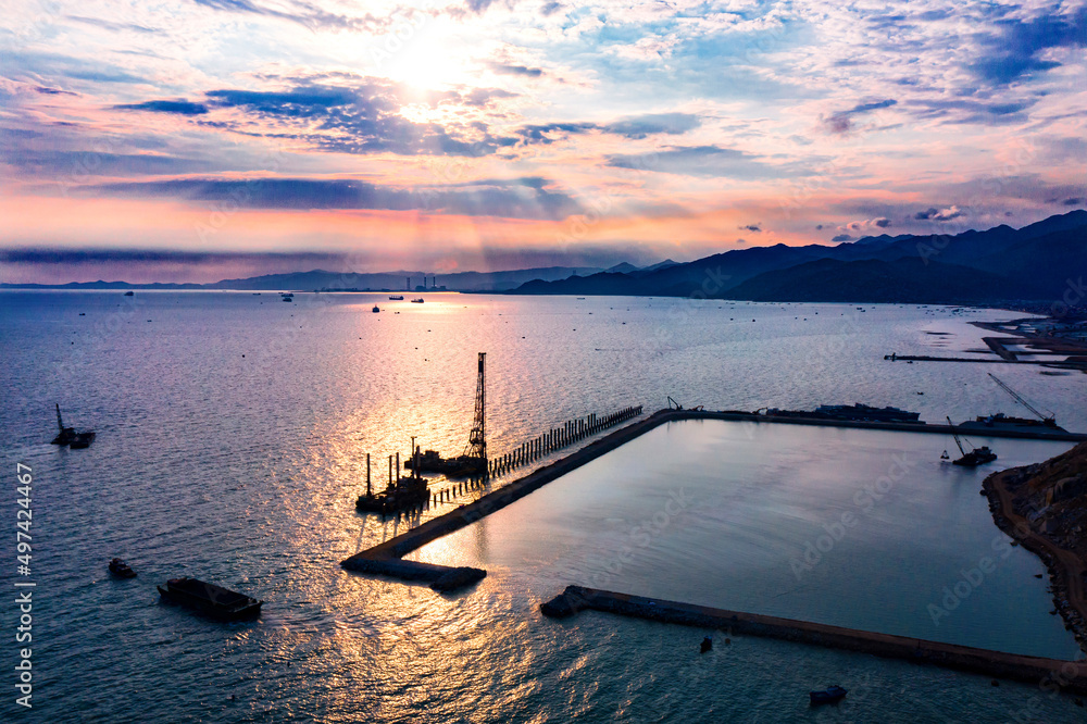 Fototapeta premium Seaport industry - Transportation and logistic . Industrial cranes and ships in the sunset.