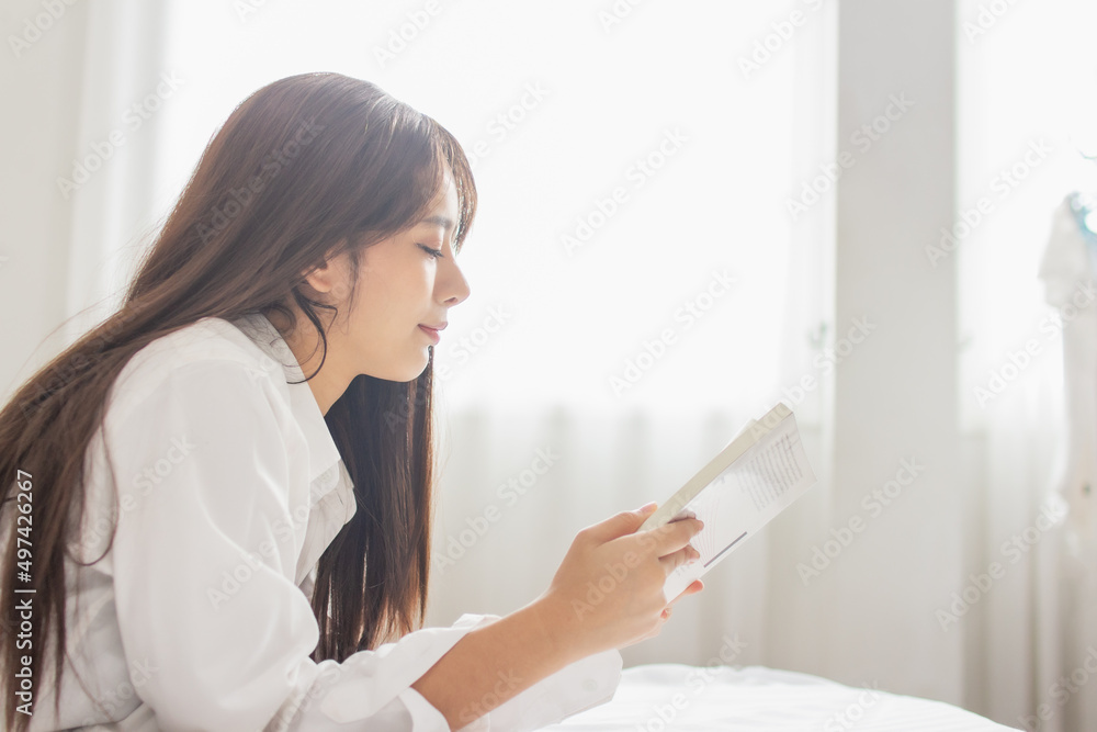 Portrait young smile happy beautiful asian woman relax bedroom. Young womanl reading book in morning Portrait young smile happy beautiful asian woman relax bedroom. Young womanl reading book in morning