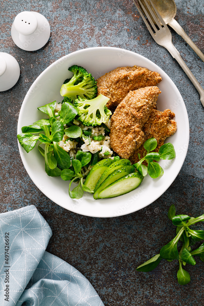 Chicken nuggets with fresh corn salad, broccoli, cucumber and rice. Top view Chicken nuggets with fresh corn salad, broccoli, cucumber and rice. Top view