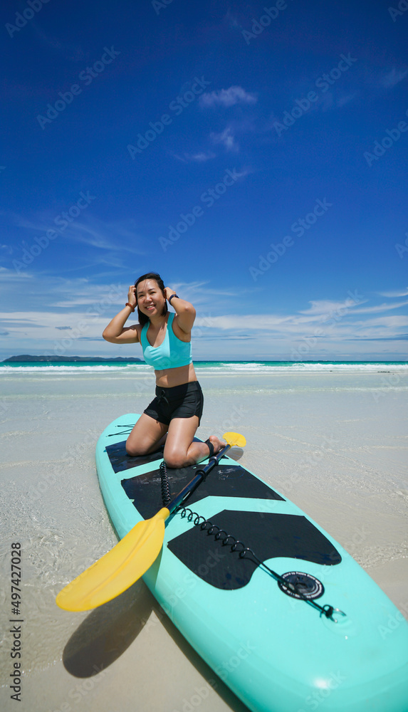 Obraz premium woman on sup board at the beach