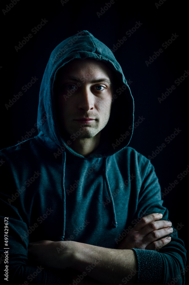 Portrait of a handsome young blue-eyed hooded man with his arms crossed Portrait of a handsome young blue-eyed hooded man with his arms crossed