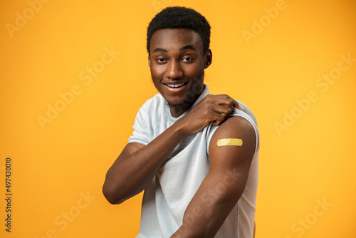 Canvastavla Vaccinated african american man showing his arm against yellow background