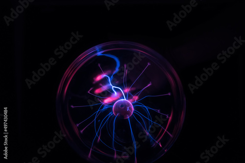 Hands holding plasma light ball on black background