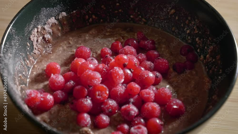 A close up shot of a black dessert bowl filled with a mixture of oatmeal, protein powder and low fat cheese, as tasty frozen red currants are added to the dish creating a low calorie protein pudding A close up shot of a black dessert bowl filled with a mixture of oatmeal, protein powder and low fat cheese, as tasty frozen red currants are added to the dish creating a low calorie protein pudding