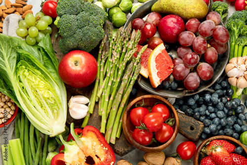 Delicious raw fruits and vegetables on light background.