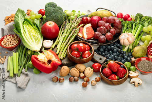 Delicious raw fruits and vegetables on light background.