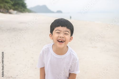 Portrait cute boy playing in the sandy beach, happy and Smiling child.
