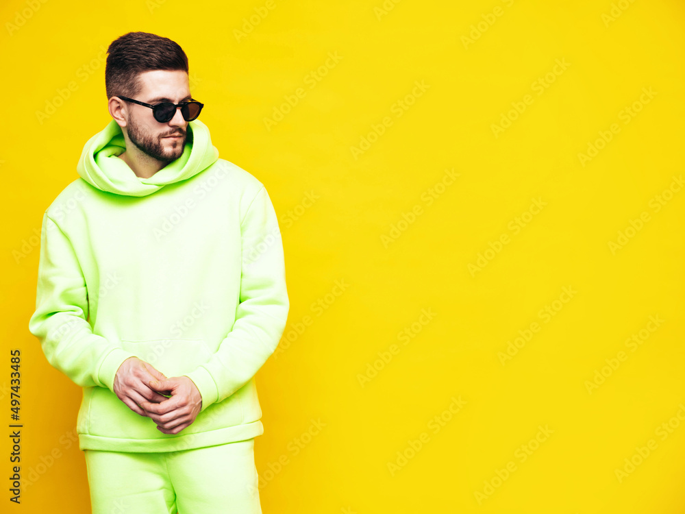 Portrait of handsome confident model. Sexy stylish man dressed in yellow hoodie with no logo. Clothes branding mockup. Design template for casual sportswear. Fashion male isolated in studio Portrait of handsome confident model. Sexy stylish man dressed in yellow hoodie with no logo. Clothes branding mockup. Design template for casual sportswear. Fashion male isolated in studio