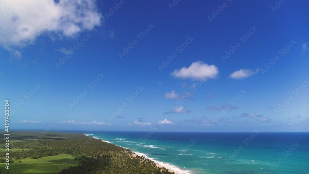 Endless blue ocean under a blue cloudy sky. Wildlife of the Dominican Republic on a sunny day. Sea voyage to tropical paradise. Holidays in the Caribbean. Palm jungle along the coastline. Endless blue ocean under a blue cloudy sky. Wildlife of the Dominican Republic on a sunny day. Sea voyage to tropical paradise. Holidays in the Caribbean. Palm jungle along the coastline.