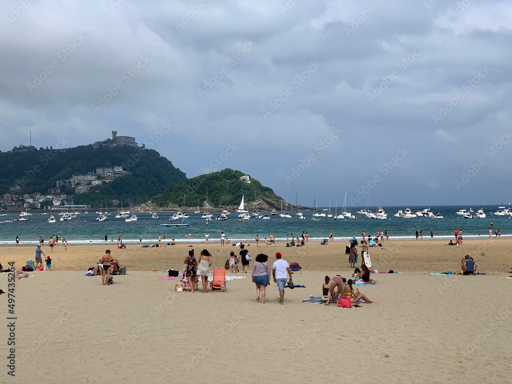 People enjoying summer day at San Sebastian beach La Concha in Basque Country People enjoying summer day at San Sebastian beach La Concha in Basque Country