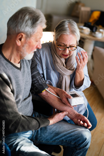 Senior couple at home measuring blood pressure. Home monitoring people healthcare concept