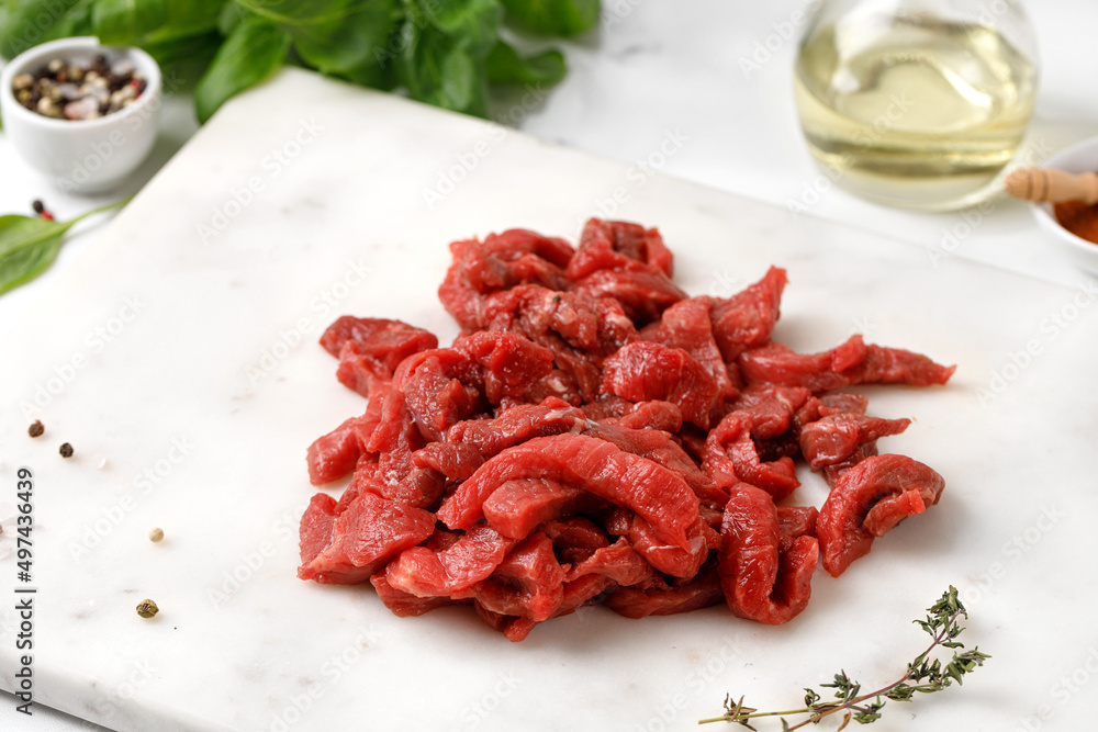 Uncocked Beef sliced meat, raw organic meat, beef strips. Small pieces of meat with pepper, dried herbs Uncocked Beef sliced meat, raw organic meat, beef strips. Small pieces of meat with pepper, dried herbs