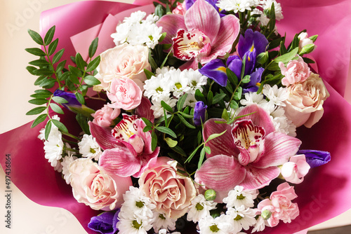 Mother's day, womens day or birthday card. Beautiful bouquet of blooming orchids, carnations and irises.