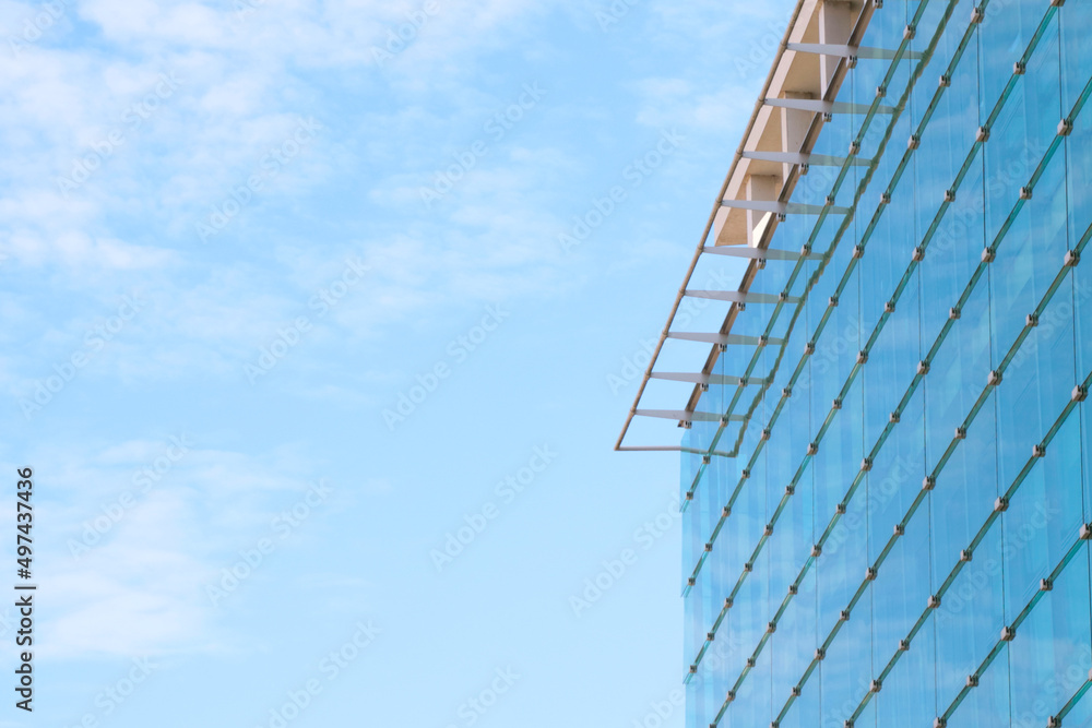 A modern glass building against a blue sky. A modern glass building against a blue sky.